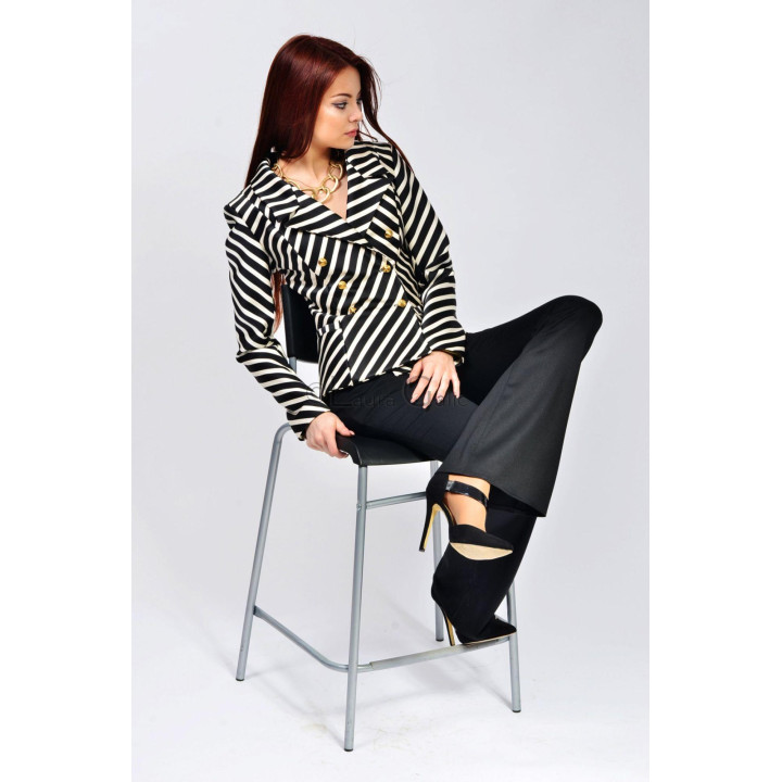 Striped jacket and black flared trousers styled in a seated pose