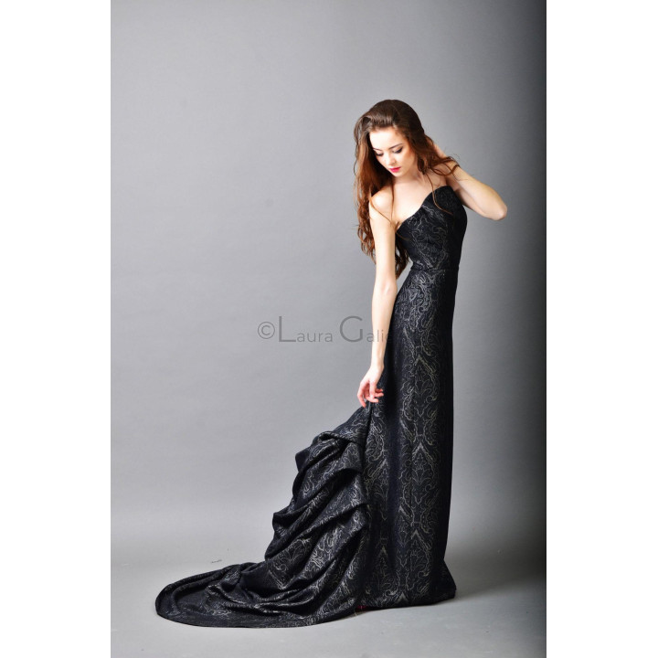Valentina 2 fitted black gown with its train spread behind the silhouette