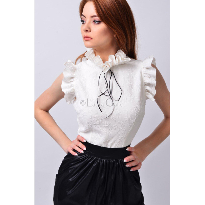 Close-up of the Frida shirt's ruffled collar, black bow and raised floral texture