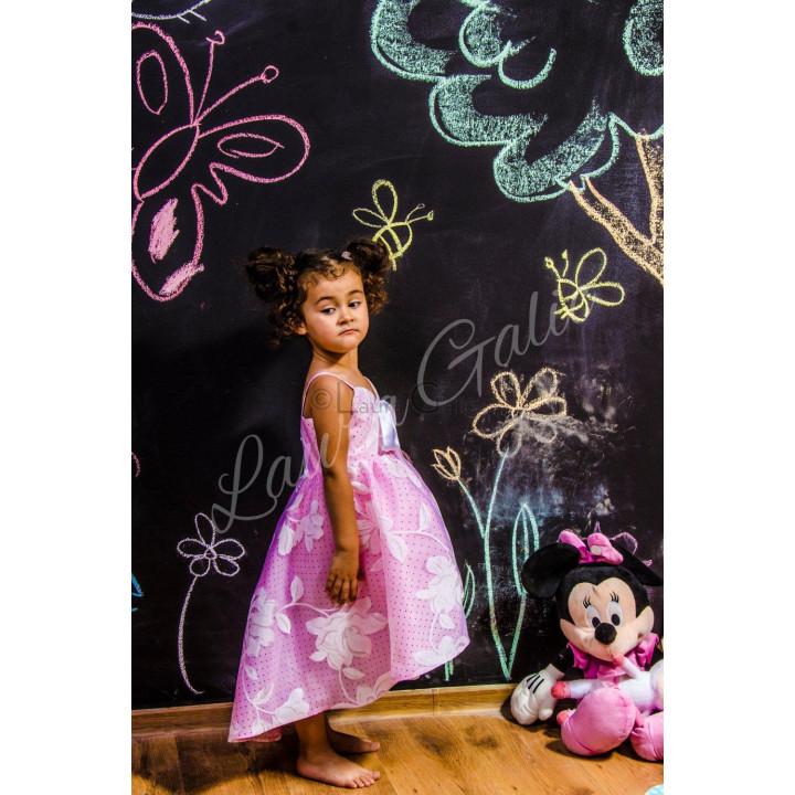 Side view of a pink floral girls' dress with an asymmetrical hem