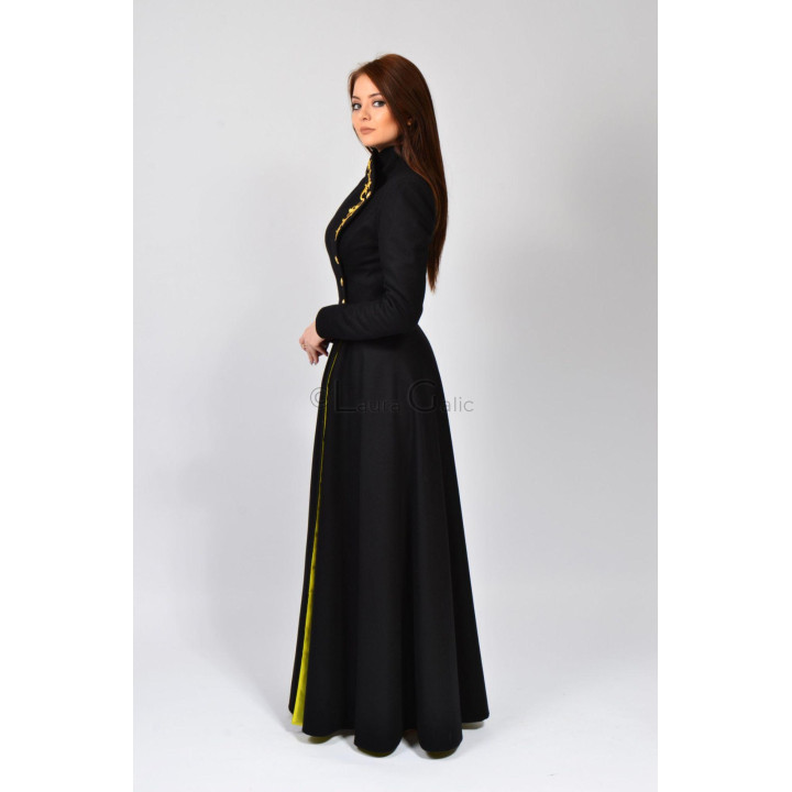 Tamura long coat from the side, with a fitted waist and yellow detail along the front opening