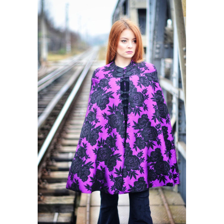 Front view of the Uhura jacket-cape with a black floral pattern and decorative fastenings