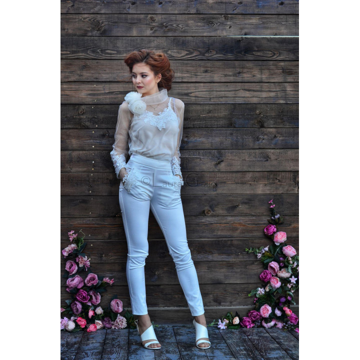 White fitted trousers featuring a wide waistband and lace appliqués