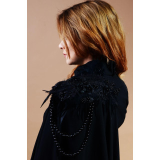 Close-up of bead and feather appliqués on the shoulder of the black Euridice cape jacket