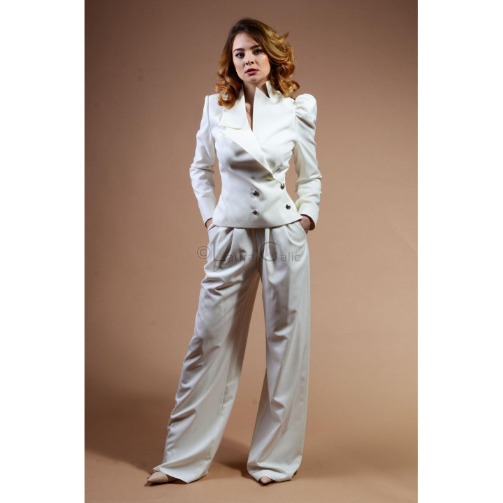 Costum alb Perla cu sacou cu rever amplu și pantaloni largi, purtat cu pantofi nude