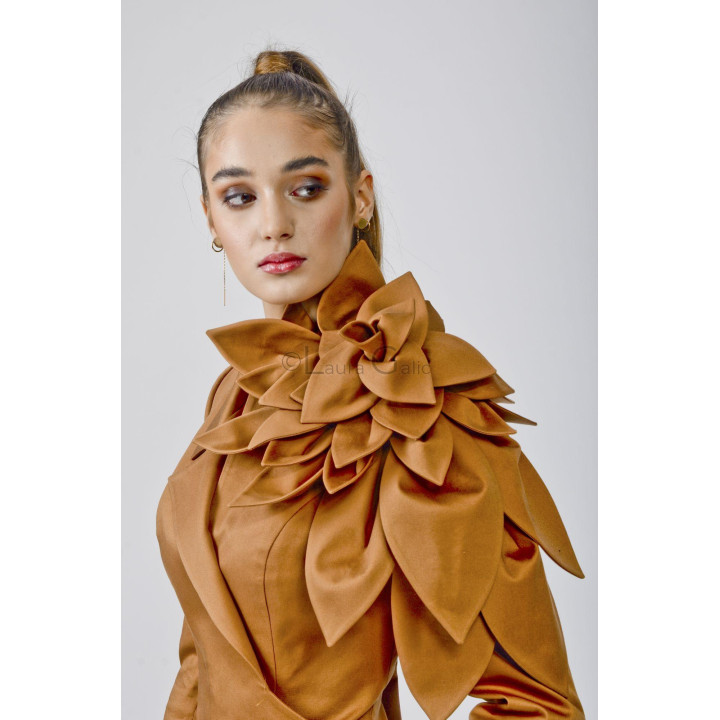 Close detail of the oversized layered flower on the camel Delia blazer's shoulder