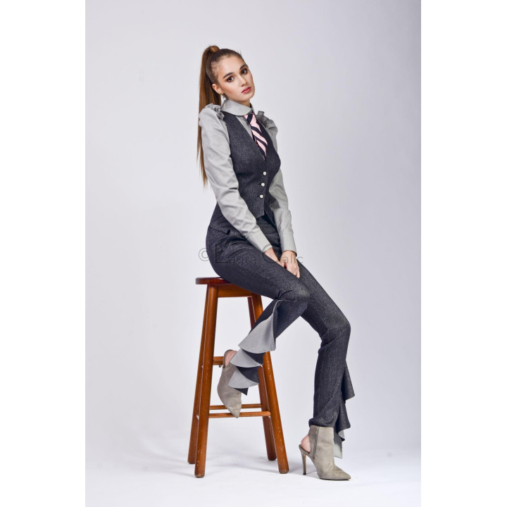 Iris trousers with light grey ruffles at the hems, shown in a seated look