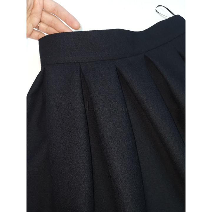 Close-up of the waistband and pleats on a black Gina skirt