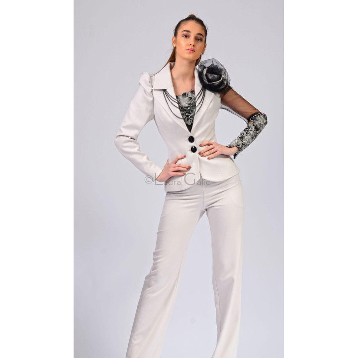 Sacoul alb Aurelia 2 încheiat cu nasturi negri și decorat cu lanțuri și floare la umăr