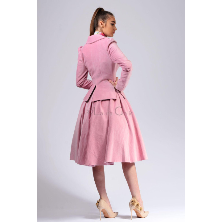 Back view of the Cara suit showing its fitted jacket and pleated Marisa skirt