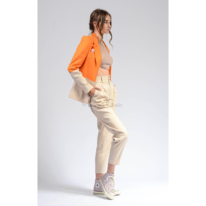 Side view of the Ramona Split suit with orange blazer and high-waisted cream trousers