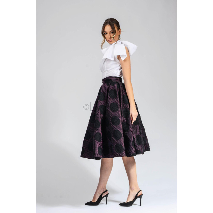 Full midi silhouette of the Marisa skirt with a plum-purple ground and black circle pattern