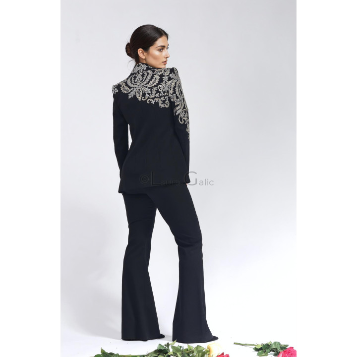 Back view of the Freida suit showing ornamental appliqués across the jacket shoulders and sleeves