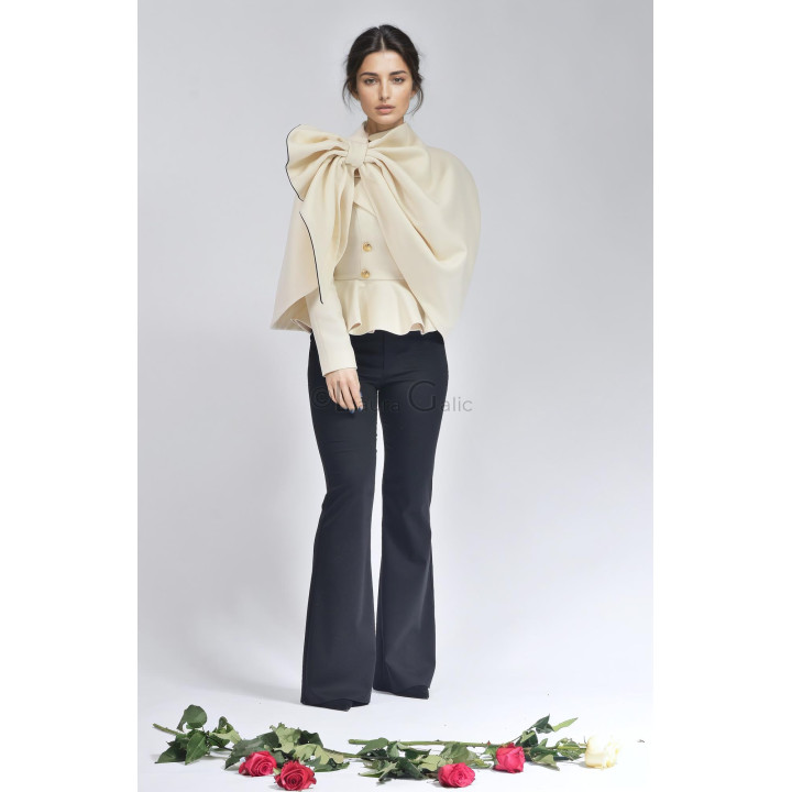 Costumul Carmen purtat cu capă ivory cu margine neagră și pantaloni evazați