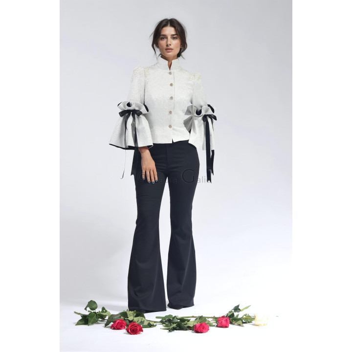 Federica 2 brocade jacket styled with black trousers, featuring dramatic sleeves and contrasting ribbon bows