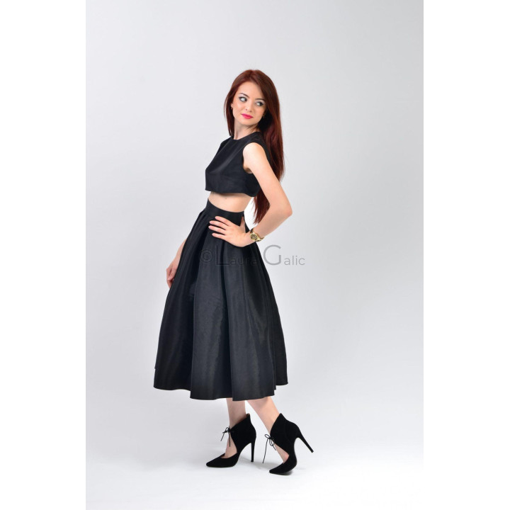 Fusta Marisa văzută din profil, cu pliuri ample și lungime midi