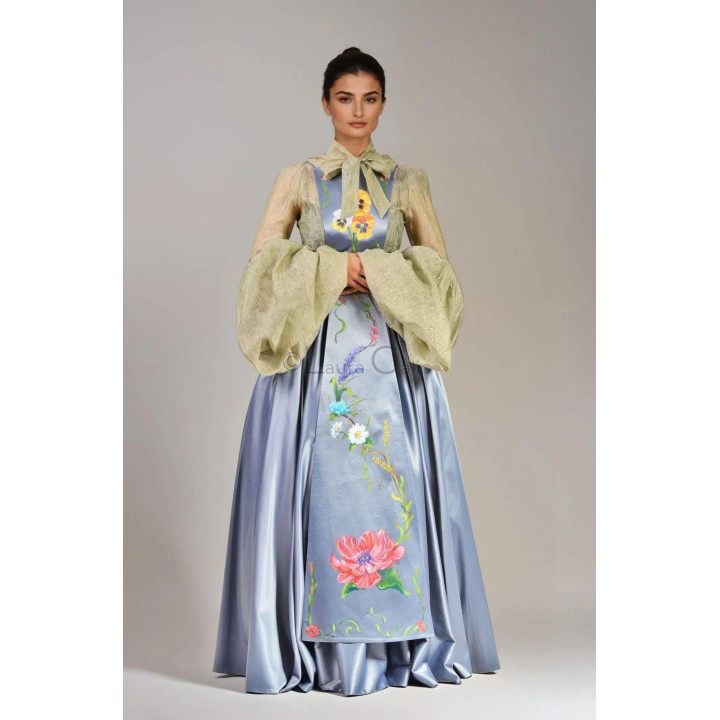 Catrinta picatata floral apron worn over an occasion outfit, with a painted front panel