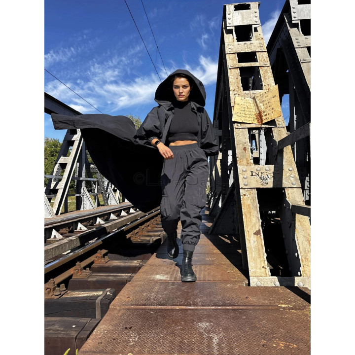 Black hooded cape with a long train styled in a contemporary outfit