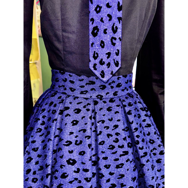 Close-up of the Marisa skirt's pleats, waistband and irregular black pattern on violet fabric