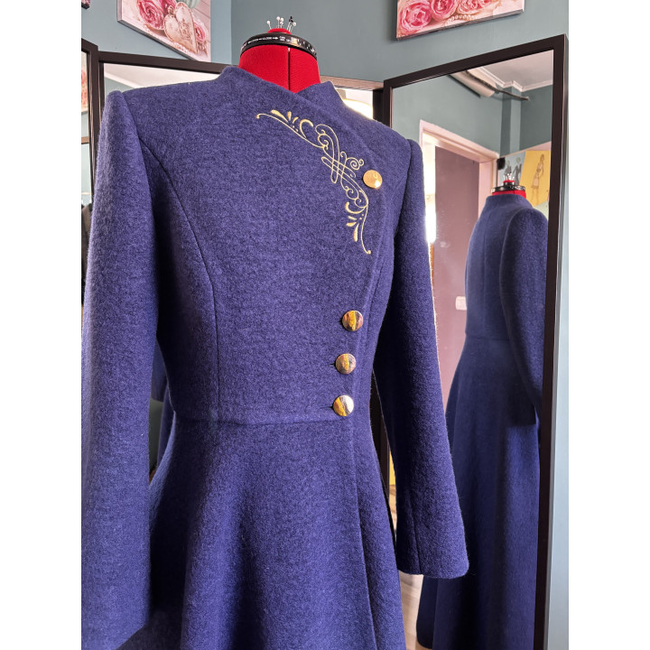 Front detail of the Tamura coat showing gold embroidery, asymmetrical fastening and fitted waist